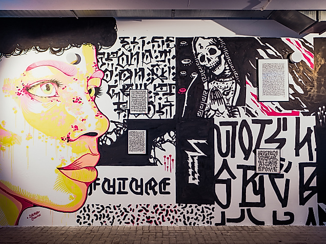 Schwarz-weißes Wandbild mit farbigem Porträt und Schriftzügen bei der Millerntor Gallery in Hamburg.