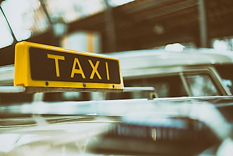 Gelbes Taxischild auf einem Auto, Symbolbild für barrierefreie Taximobilität in Hamburg.