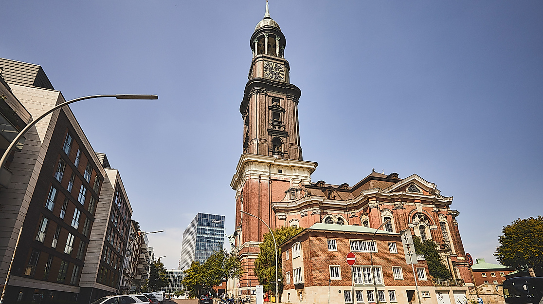 Barockkirche St. Michaelis mit markantem Turm und kupferner Haube bei blauem Himmel