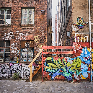 Graffiti und Streetart an Backsteinfassade mit bunter Treppe im Gängeviertel Hamburg