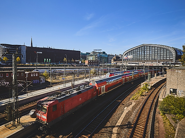 Regionalzug der DB vor dem Hamburger Hauptbahnhof bei Sonnenschein und klarem Himmel.