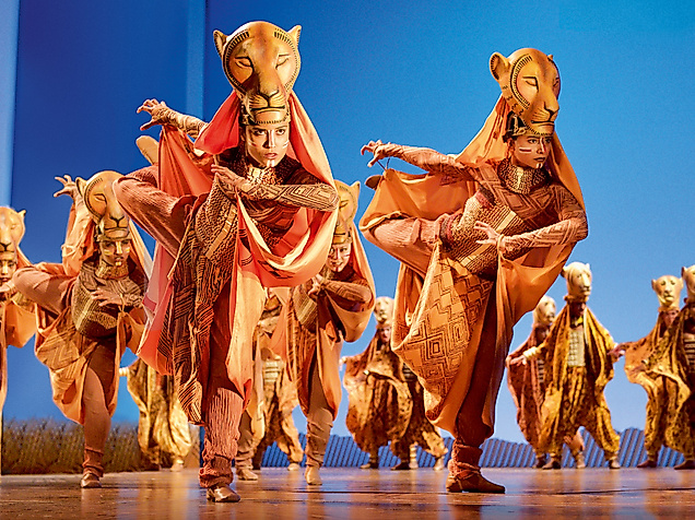 A scene from Disney's musical The Lion King with costumed lionesses dancing.