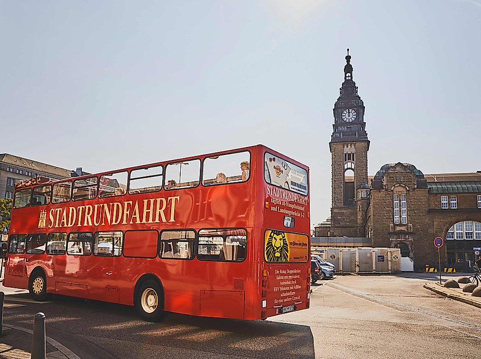 A red double-decker bus in front of the Landungsbrücken in Hamburg.