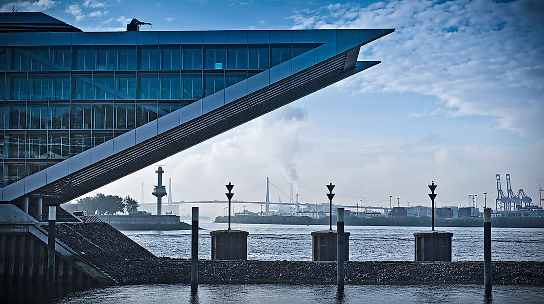 Dockland-Gebäude in Hamburg mit markanter Architektur und Blick auf den Hafen bei blauem Himmel.