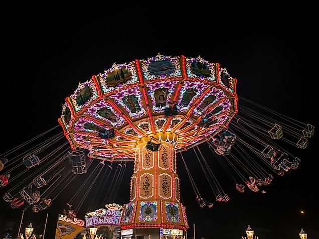 Leuchtendes Kettenkarussell bei Nacht auf dem Winterdom in Hamburg
