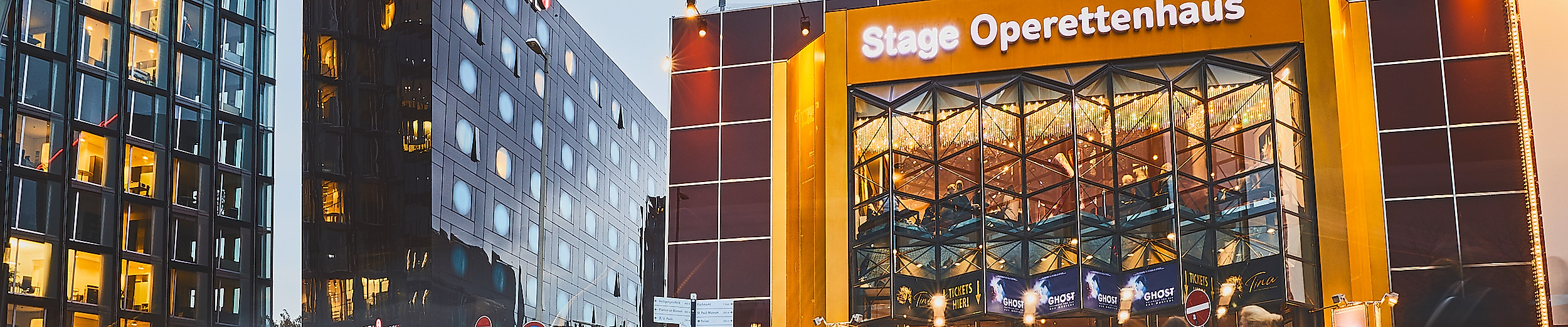 Beleuchtetes Stage Operettenhaus auf der Reeperbahn bei Abenddämmerung mit Lichtspuren vorbeifahrender Autos