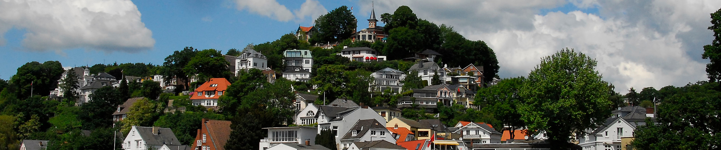 Blick auf das Treppenviertel in Hamburg-Blankenese mit weißen Häusern am Elbhang bei Sonnenschein