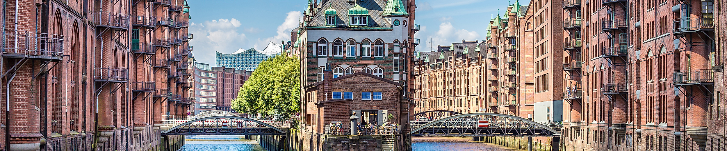 Historische Speicherstadt Hamburg mit Wasserwegen und roten Backsteingebäuden bei Sonnenschein.