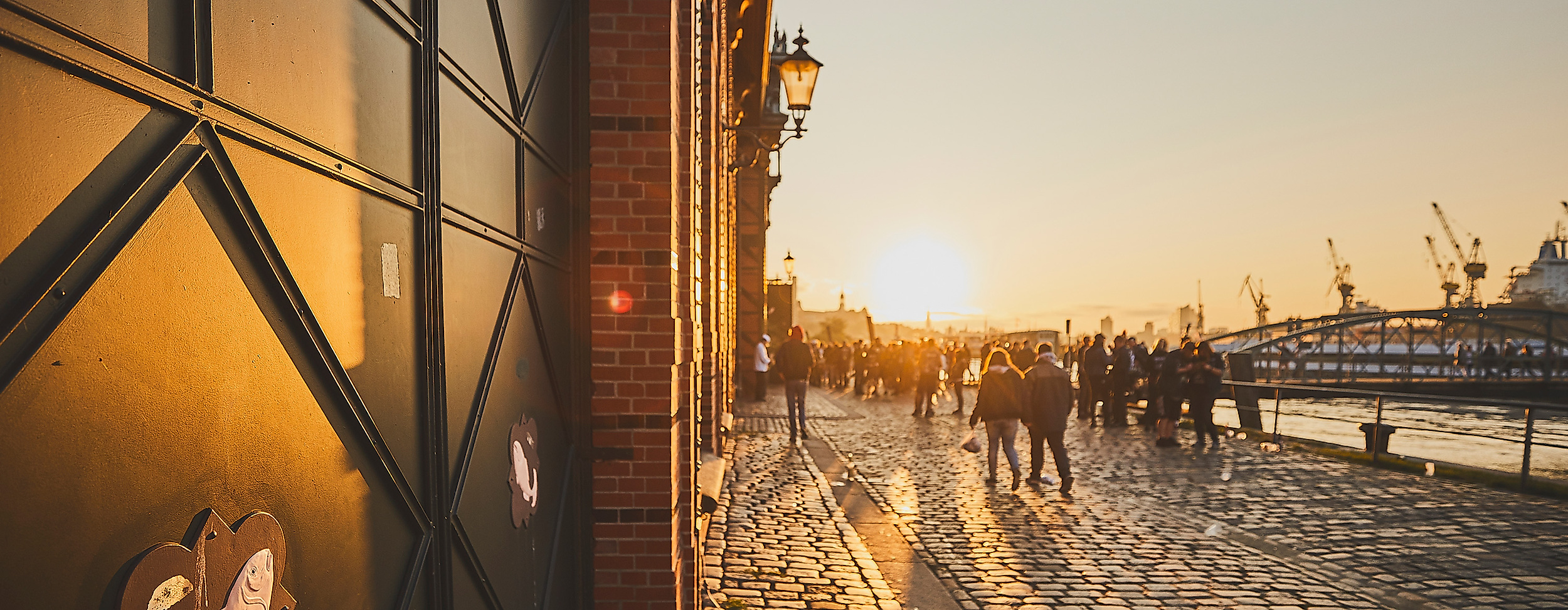 Morgensonne am Hamburger Fischmarkt mit Licht auf Tor der Fischauktionshalle und Blick zum Hafen