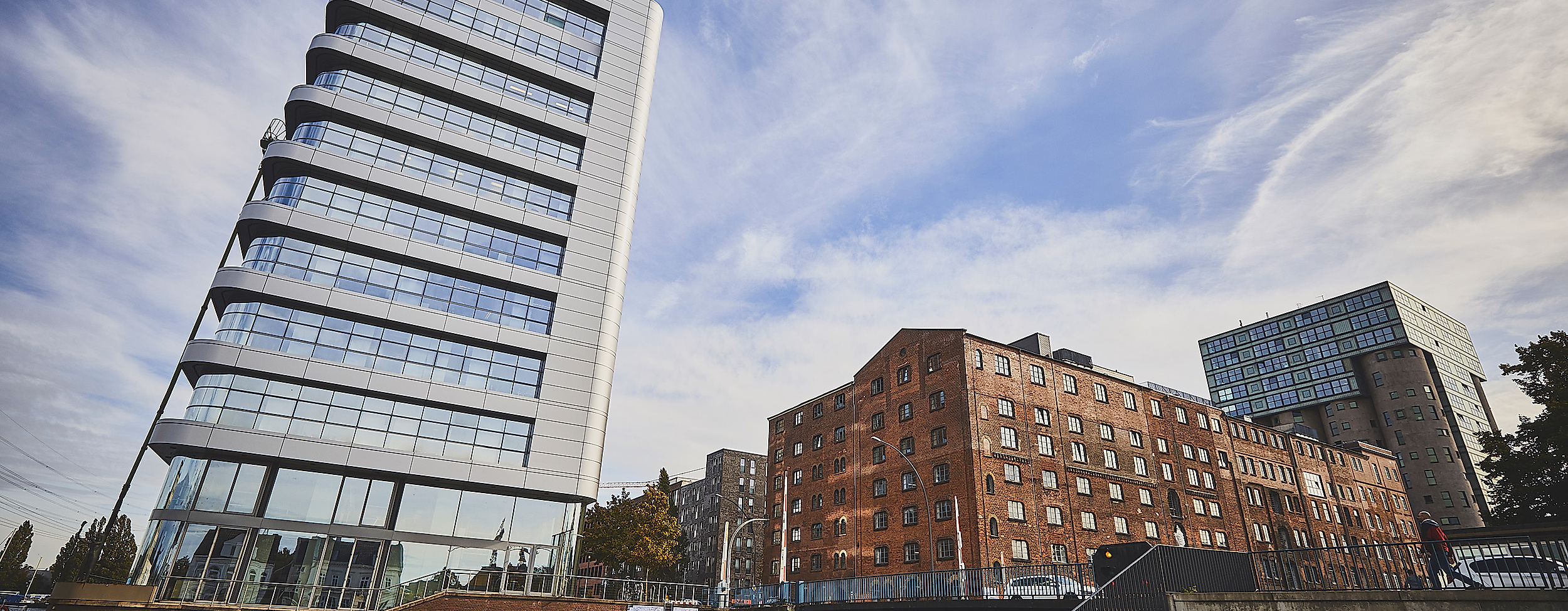 Moderne Gebäude am Lotsekanal in Harburg mit schrägem Büroturm und Uferpromenade
