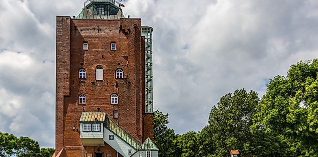 Backsteinleuchtturm auf Neuwerk mit Besucherzugang, umgeben von Bäumen 