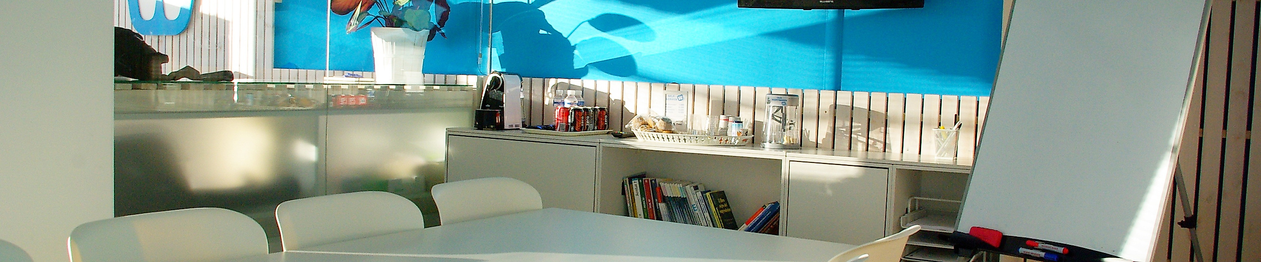 Modern gestalteter Coworking-Space in Hamburg mit großem Tisch, Flipchart und TV in kreativem Ambiente.