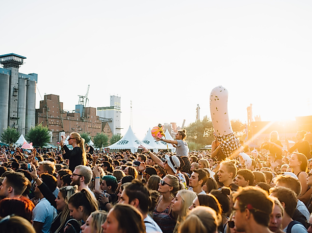 Festivalbesucher:innen beim MS Dockville in Hamburg bei Sonnenuntergang vor urbaner Kulisse