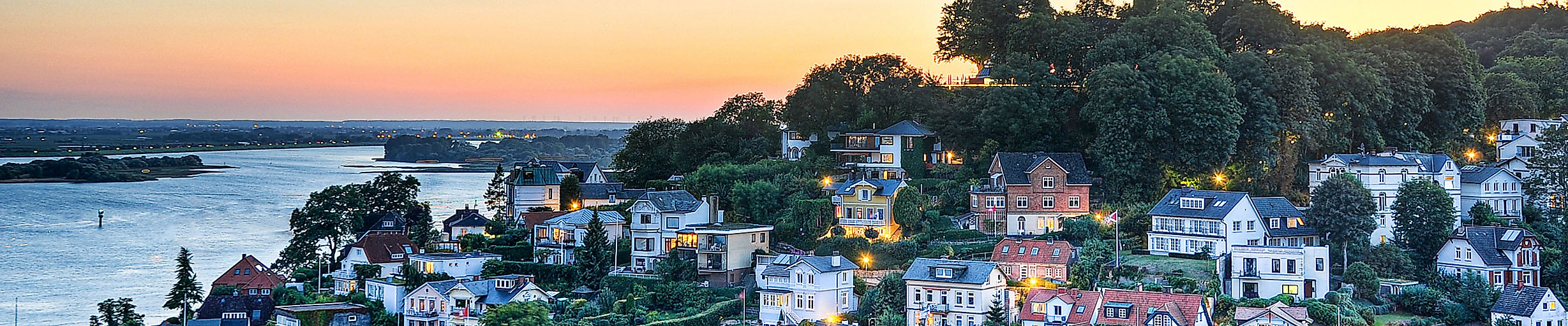 Abendstimmung über dem Blankeneser Treppenviertel mit Blick auf weiße Häuser und die Elbe im Sonnenuntergang