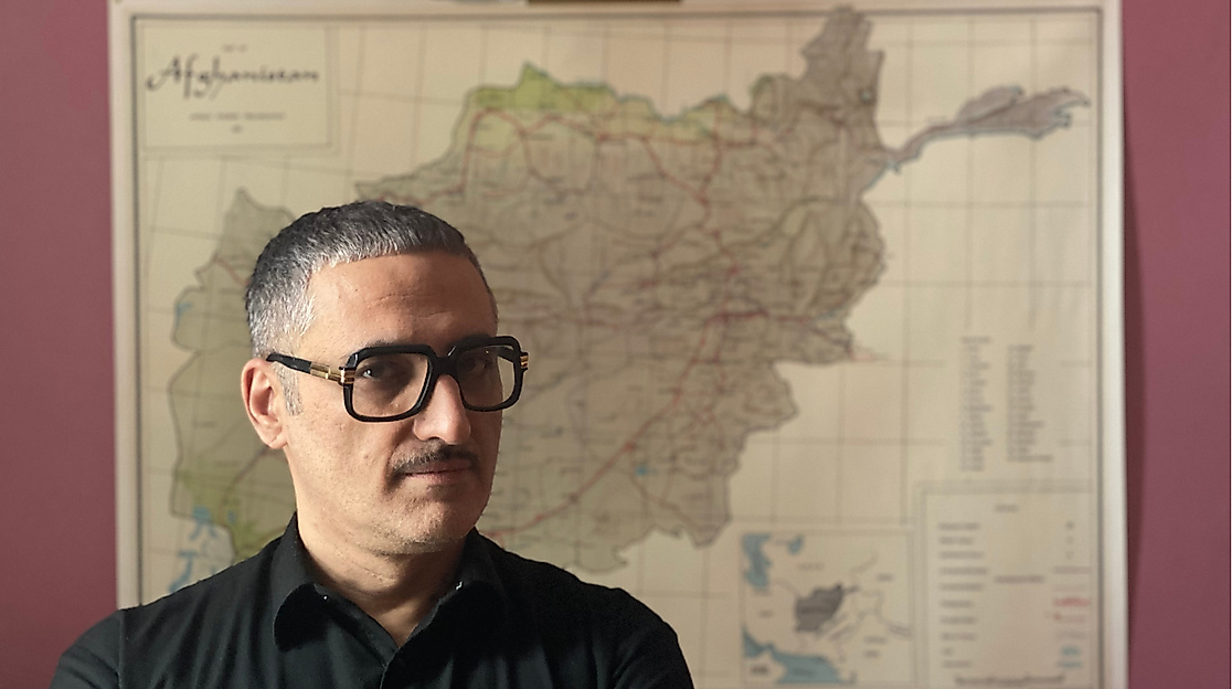 Prof. Dr. Fahim Amir stands in front of a map, looking serious