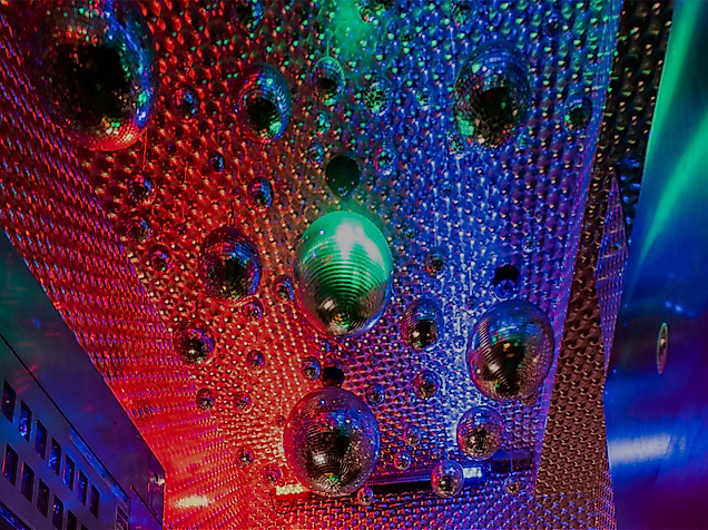 Decke mit Spiegelkugeln und bunten LED-Lichtern sorgt für dynamische Stimmung in Hip-Hop-Club.
