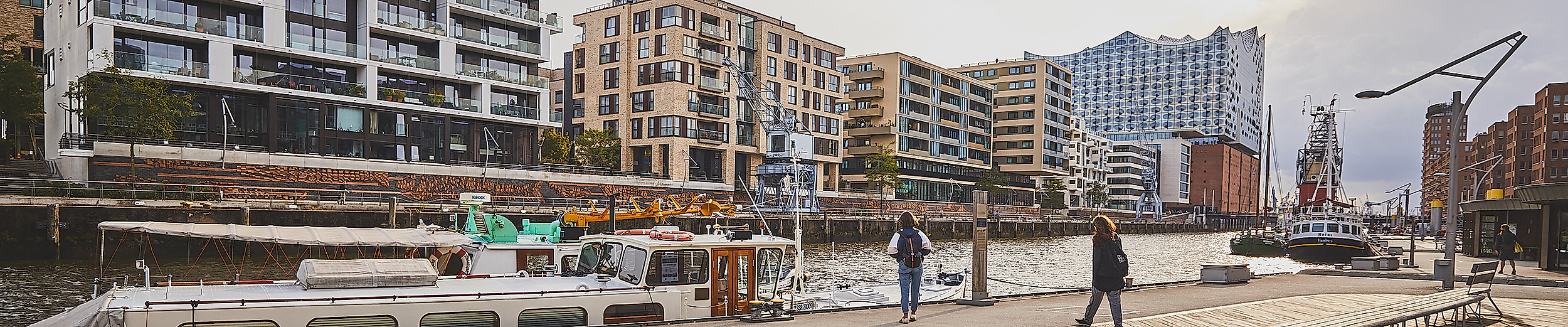 Promenade am Sandtorhafen in der HafenCity Hamburg mit Schiffen und historischen Hafenkränen