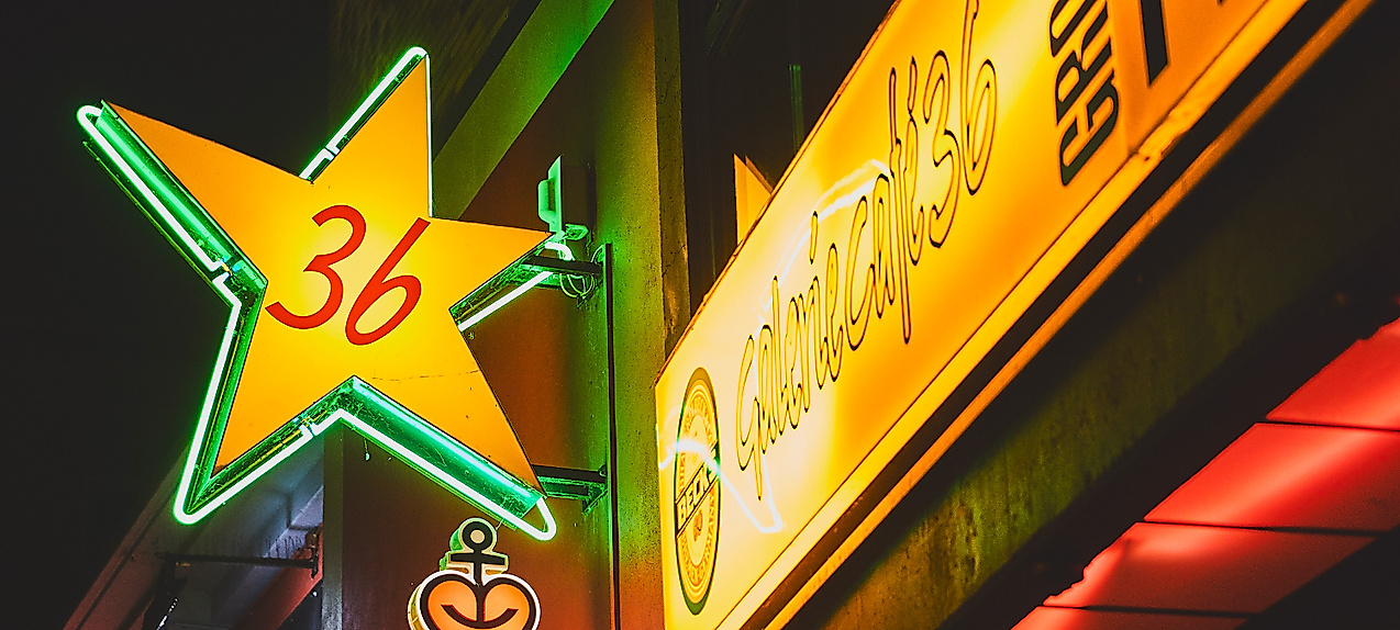 Leuchtschilder an der Großen Freiheit 36 auf St. Pauli mit grünem Stern und Astra-Logo bei Nacht