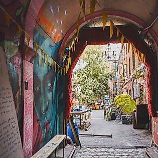 Bunter Durchgang im Gängeviertel Hamburg mit Graffiti, Kunstinstallationen und Blick in begrünten Innenhof