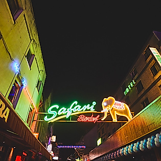 Neonbeleuchteter Eingang zum Safari-Club auf der Großen Freiheit bei Nacht mit Kiezreklamen