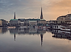 Abendstimmung an der Binnenalster mit Stadtspiegelung im Wasser und Blick auf historische Gebäude