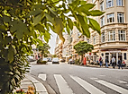 Belebte Straßenszene im Portugiesenviertel mit Restaurants und Altbaufassaden an einem sonnigen Tag