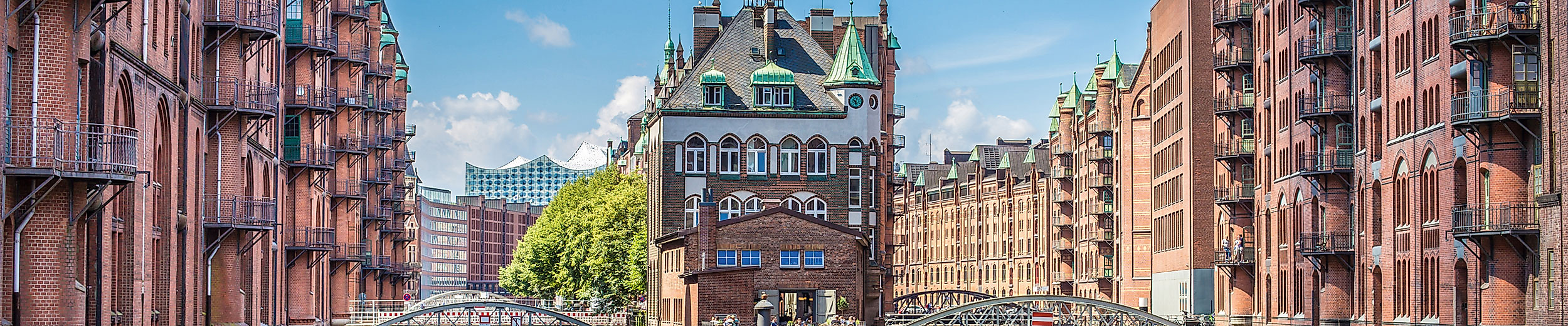 Historische Speicherstadt Hamburg mit Wasserwegen und roten Backsteingebäuden bei Sonnenschein.