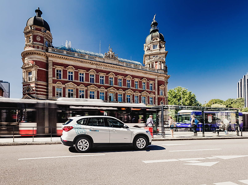 DriveNow-Auto vor der Alten Oberpostdirektion Hamburg, mit vorbeifahrendem HVV-Bus