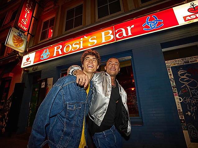 Zwei Männer Arm in Arm auf dem Hamburger Berg vor einer Kneipe