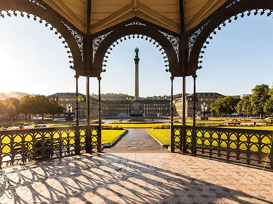Blick vom Pavillon auf dem Stuttgarter Schlossplatz zur Jubiläumssäule bei tief stehender Sonne.