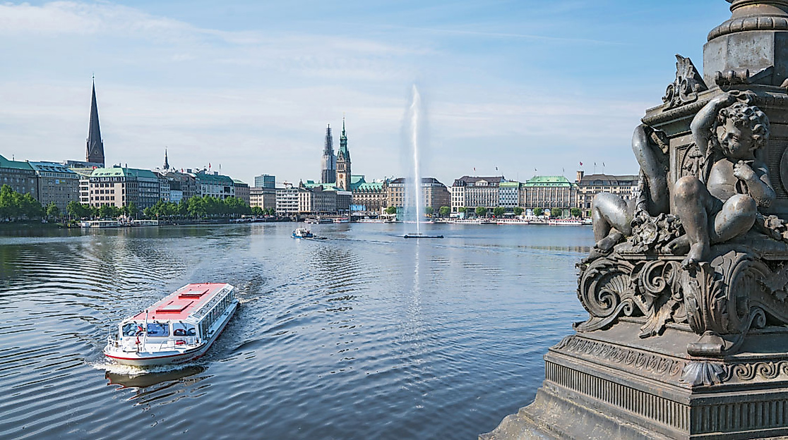 Alsterdampfer auf der Binnenalster in Hamburg mit Blick auf Fontäne, Uferpromenade und Rathaus im Hintergrund