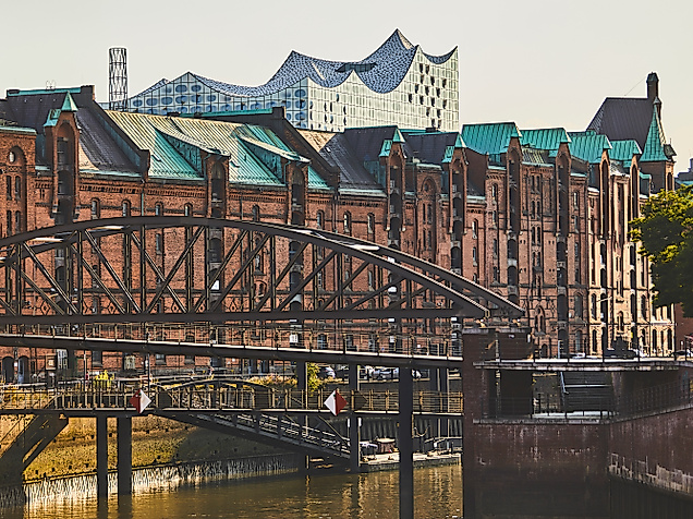 Blick über Brücken und Backsteinbauten der Speicherstadt auf die Elbphilharmonie im Hintergrund.