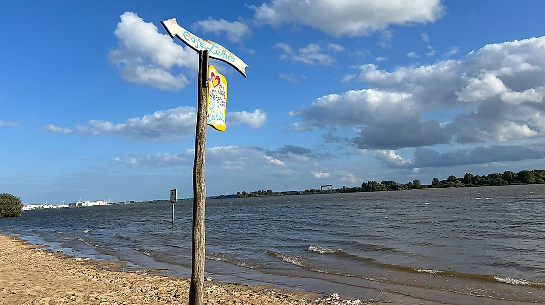 Elbstrand in Blankenese mit Warnschild und weitem Blick über die Elbe bei blauem Himmel