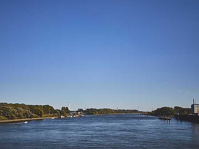 Blick über die Elbe in Hamburg bei blauem Himmel, mit Uferbebauung und Fernsehturm in der Ferne
