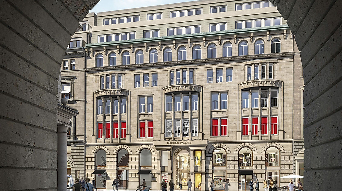 Blick durch steinernen Torbogen auf das Bucerius Kunst Forum mit klassizistischer Fassade und roten Bannern