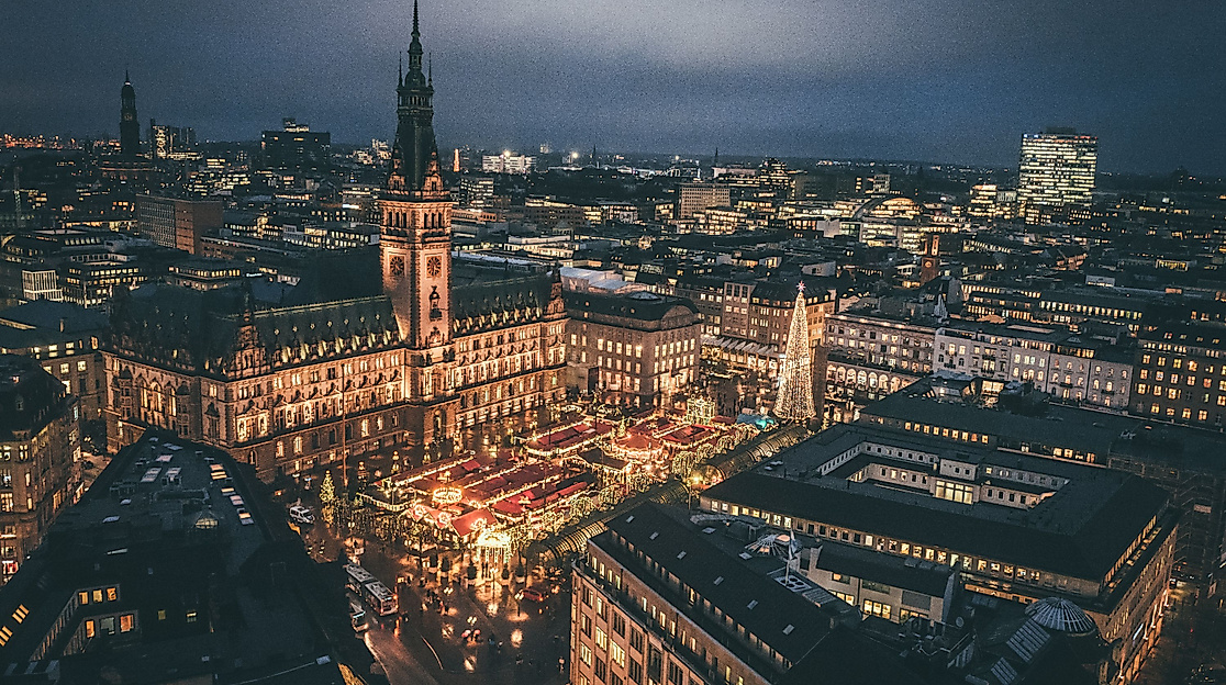 Luftaufnahme der festlich beleuchteten Hamburger Innenstadt mit Weihnachtsmarkt am Rathaus bei Nacht