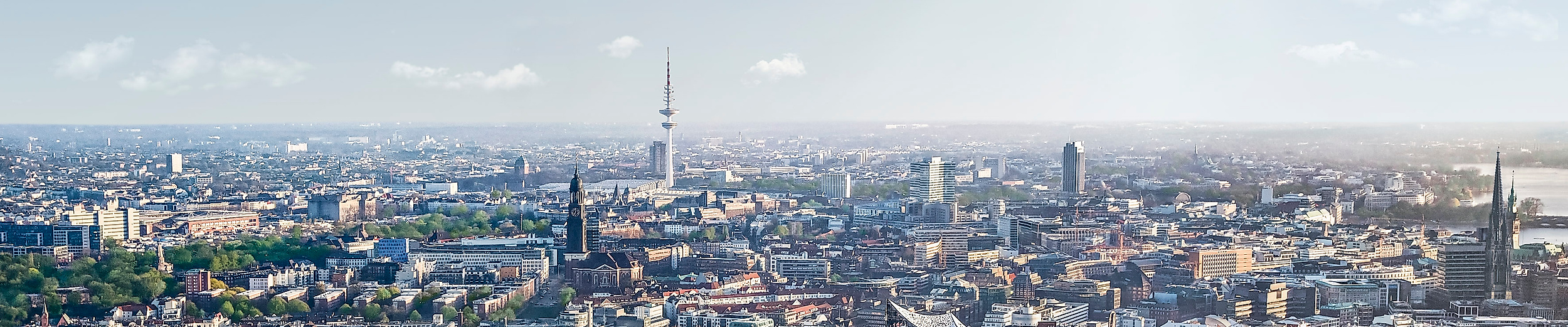 AIDAnova passiert bei Sonnenschein die Elbphilharmonie auf der Elbe vor der Hamburger Skyline