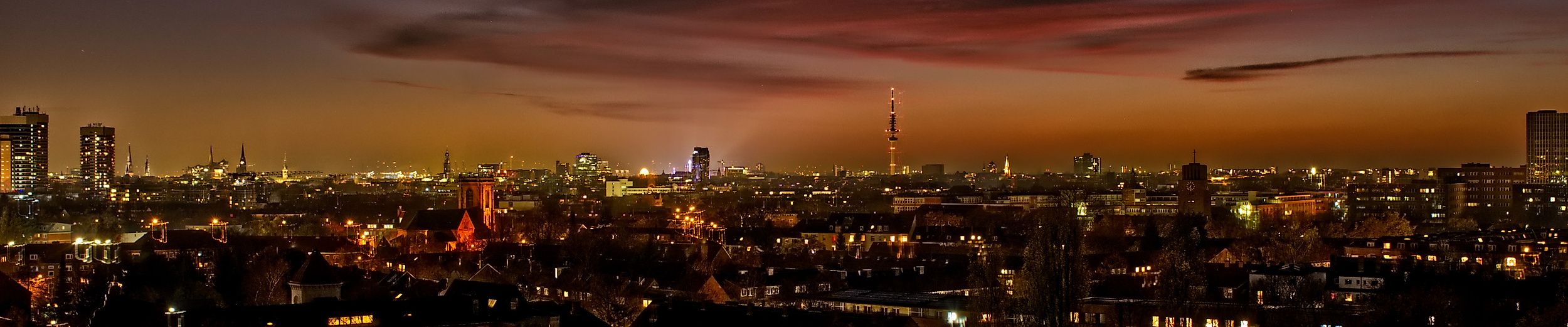 Beleuchtete Stadtsilhouette von Hamburg bei Nacht mit farbigem Abendhimmel und Skyline