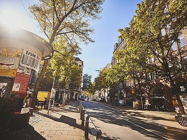 Belebte Lange Reihe in Hamburg-St. Georg bei Sonnenschein mit Passant:innen, Bäumen und Caféterrassen