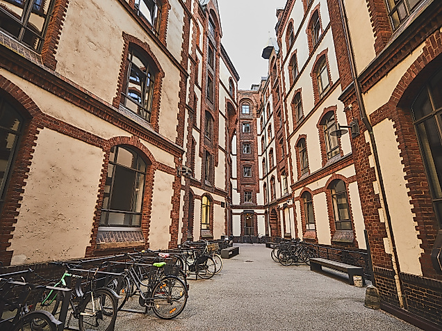 Schmaler Innenhof am Sandtorkai, umgeben von historischen Backsteinfassaden mit Rundbogenfenstern