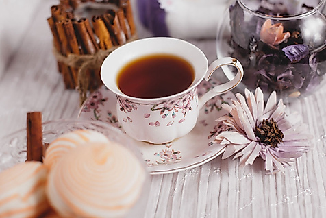 Feine Teetasse mit Schwarztee, Gebäck und Blüte als Hommage an britische Teekultur in Hamburg
