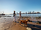 A young couple walks their dog along the Elbe River.