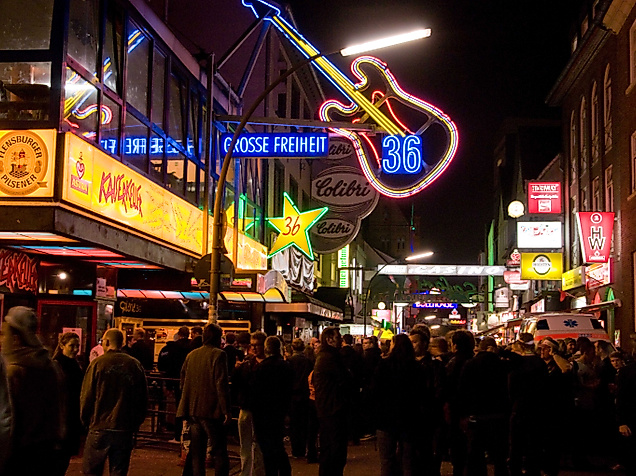 Belebte Große Freiheit bei Nacht mit leuchtenden Clubschildern und Gitarren-Neonreklame
