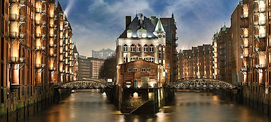 Beleuchtete Speicherstadt mit Wasserschloss in der blauen Stunde, ikonisches Wahrzeichen Hamburgs